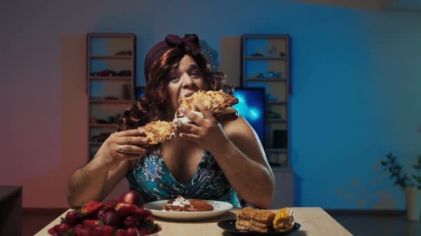 Man dressed in womans dress and makeup on face eats a huge sandwich — Stock Video