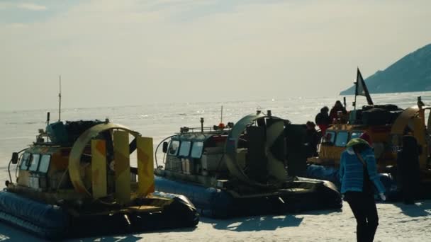 凍った湖の岸には、冬にいくつかのホバークラフトが駐車されています — ストック動画