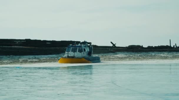 Hovercraft rides on frozen lake ice among snow capped mountains — Stock Video