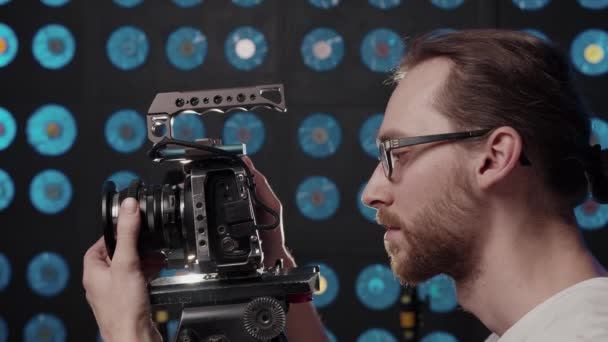 Videografo imposta una fotocamera per le riprese in studio e commenti. — Video Stock