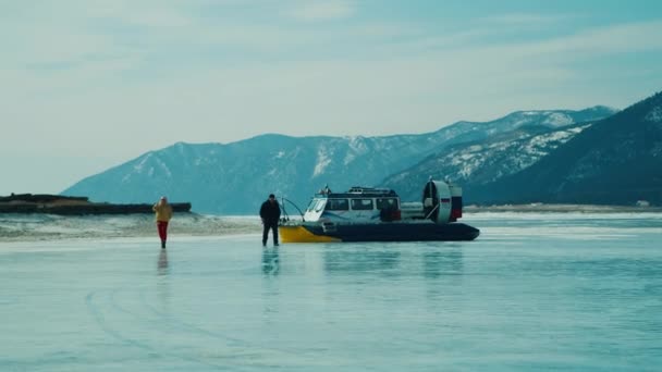 Hovercraft promenades sur glace de lac gelée parmi les montagnes enneigées — Video