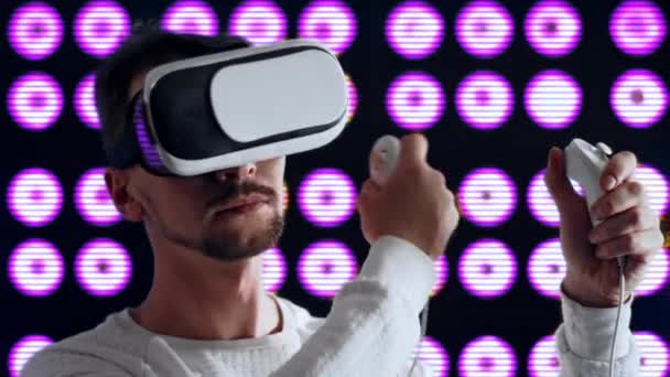 Человек в очках виртуальной реальности сушит волосы феном с помощью джойстика — стоковое видео