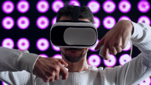 Кавказский мужчина в шлеме виртуальной реальности чистит зубы современным джойстиком — стоковое видео