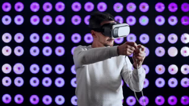 Człowiek w wirtualnej rzeczywistości okulary gra joysticks strzelanie strzałki z łuku — Wideo stockowe
