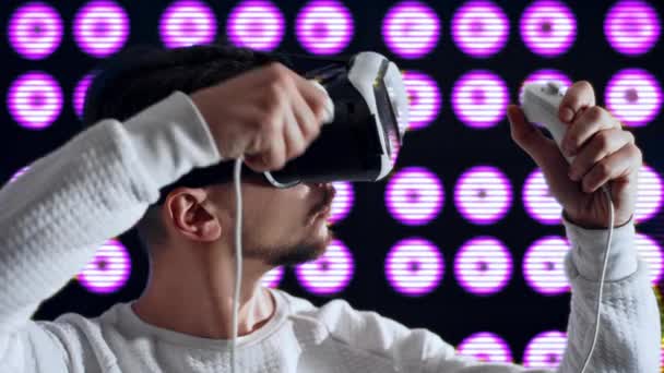 Homem em óculos de realidade virtual seca o cabelo com secador de cabelo usando joystick — Vídeo de Stock