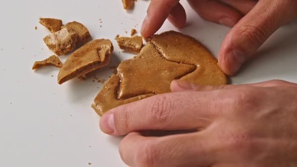 Las manos de los hombres rompen galletas de azúcar dulces en forma de estrella. — Vídeo de stock