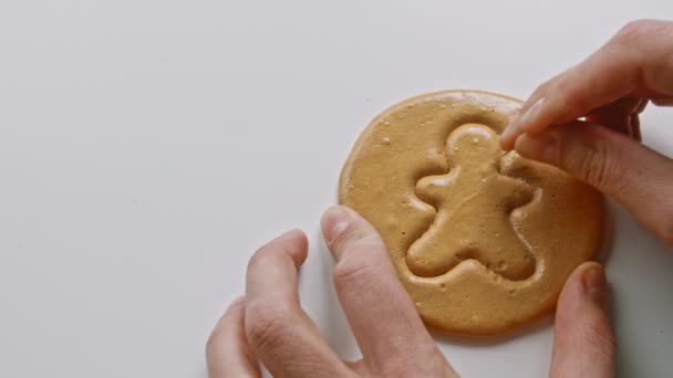 Чоловічі руки розбивають цукрове печиво цукерки у формі чоловіка . — стокове відео
