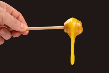 Tahta kaşıktan düşen taze, yapışkan bir çiçek balı. vitamin organik gıdalar