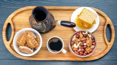 Hindi ve kurutulmuş turunçgil, fındık ve bal peteği ile birlikte mutfak tahtasının üzerinde taze kahve. İnsan vücudu için yararlı vitamin yiyeceği