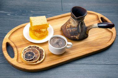 Hindi ve kurutulmuş narenciye ile taze kahve ve mutfak tahtasının üzerinde bal peteği. İnsan vücudu için yararlı vitamin yiyeceği