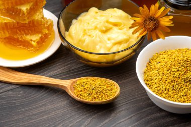 Farklı çeşitlerde taze çiçek balı, polen ve ahşap arka planda kaşıkları olan bal peteği. Organik Vitamin Sağlıklı Gıda