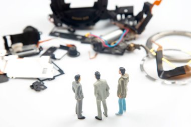 Minyatür insanlar. İşadamları elektronik cihazın parçalanmış parçalarının yanında dururlar. Girişimci konsepti