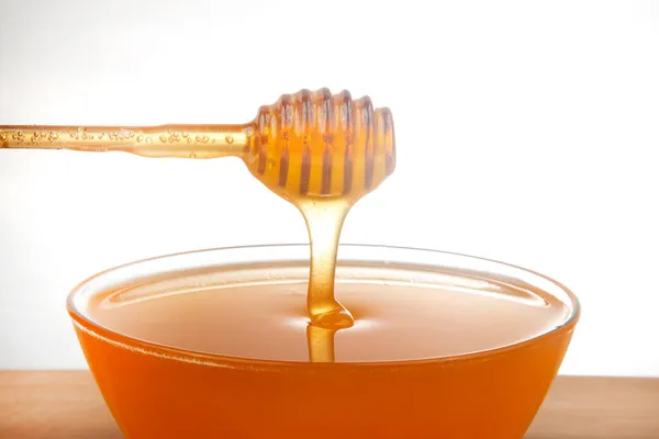 Miel Fresca Que Gotea Una Cuchara Plato Transparente Sobre Fondo —  Fotos de Stock