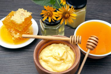 Farklı türde taze çiçek balı ve ahşap arka planda kaşıkları olan bal peteği. Organik Vitamin Sağlıklı Gıda