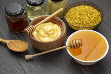 Farklı çeşitlerde taze çiçek balı, polen ve ahşap arka planda kaşıkları olan bal peteği. Organik Vitamin Sağlıklı Gıda