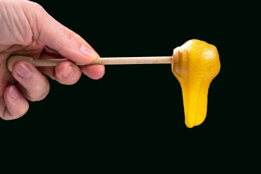 Tahta kaşıktan düşen taze, yapışkan bir çiçek balı. vitamin organik gıdalar