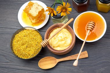 Farklı çeşitlerde taze çiçek balı, polen ve ahşap arka planda kaşıkları olan bal peteği. Organik Vitamin Sağlıklı Gıda