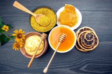 Farklı çeşitlerde taze çiçek balı, polen ve ahşap arka planda kaşıkları olan bal peteği. Organik Vitamin Sağlıklı Gıda