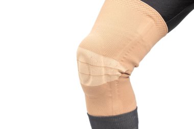 Beyaz arka planda insan bacağının yaralı dizini tedavi etmek için bandaj. Tıp ve spor. uzuv yaralanması tedavisi