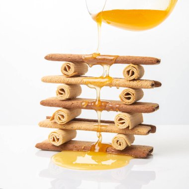 Taze çiçek balı akar ve onun çıtır kurabiye çubuklarının üzerine damlar. Atıştırmalık tatlı.