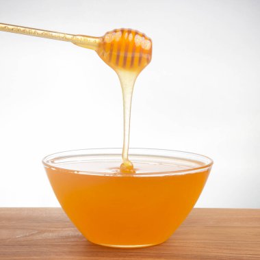 Taze kokulu bal bir kaşıktan bir tabağa damlıyor. Organik vitamin besin. Tatlı yemek.