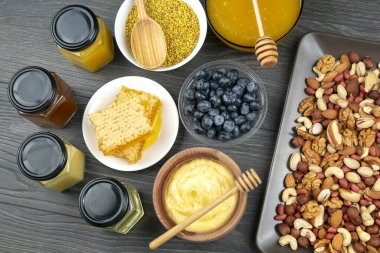 Tahta arka planda taze bal, fındık, çilek ve yaban mersini. sağlıklı organik vitamin yiyeceği.