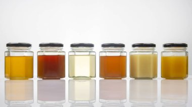 Farklı tipte ve taze çiçek rengi olan altıgen kavanozlar. Yaşam ve sağlık için vitamin gıdası