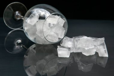 Donmuş buz küpleri, arka planda boş bir şarap kadehinde.