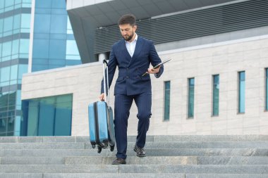 Başarılı iş adamı, ofis iş merkezinin arka planına doğru iniyor.