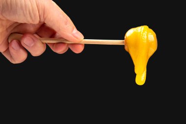 Tahta kaşıktan düşen taze, yapışkan bir çiçek balı. vitamin organik gıdalar