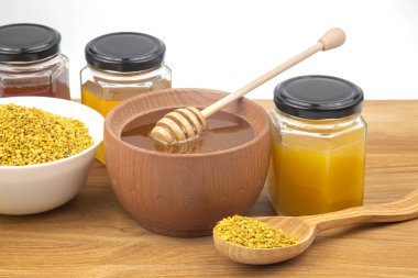 Tahta bir kasede taze çiçek balı, kaşık, polen. Yaşam ve sağlık için vitamin gıdası