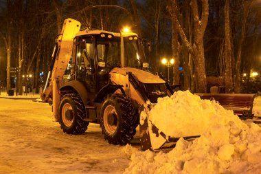 Akşamları traktörle parkta kar temizliyorum.