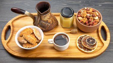 Hindi, kurutulmuş narenciye ve ahşap bir mutfak tahtasının üzerinde bal peteği ile taze kahve. İnsan vücudu için yararlı vitamin yiyeceği