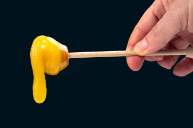 Tahta kaşıktan düşen taze, yapışkan bir çiçek balı. vitamin organik gıdalar
