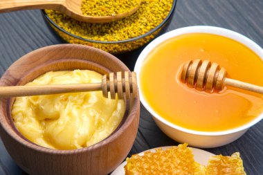 Farklı çeşitlerde taze çiçek balı, polen ve ahşap arka planda kaşıkları olan bal peteği. Organik Vitamin Sağlıklı Gıda