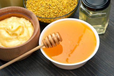 Farklı çeşitlerde taze çiçek balı, polen ve ahşap arka planda kaşıkları olan bal peteği. Organik Vitamin Sağlıklı Gıda