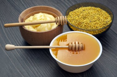 Farklı çeşitlerde taze çiçek balı, polen ve ahşap arka planda kaşıkları olan bal peteği. Organik Vitamin Sağlıklı Gıda