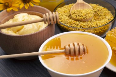 Farklı çeşitlerde taze çiçek balı, polen ve ahşap arka planda kaşıkları olan bal peteği. Organik Vitamin Sağlıklı Gıda