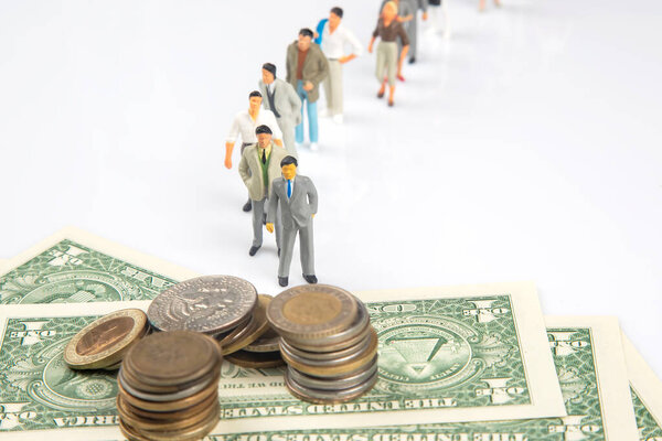 miniature people. different businessman stands near dollar money. investments and earnings for work