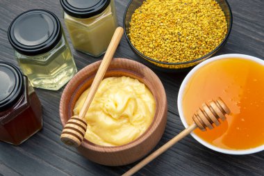 Farklı çeşitlerde taze çiçek balı, polen ve ahşap arka planda kaşıkları olan bal peteği. Organik Vitamin Sağlıklı Gıda