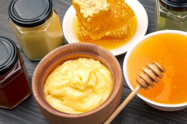 Farklı çeşitlerde taze çiçek balı, polen ve ahşap arka planda kaşıkları olan bal peteği. Organik Vitamin Sağlıklı Gıda