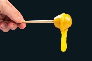 Koyu bir arka planda kaşıktan damlayan taze bal. organik vitamin sağlıklı gıdalar