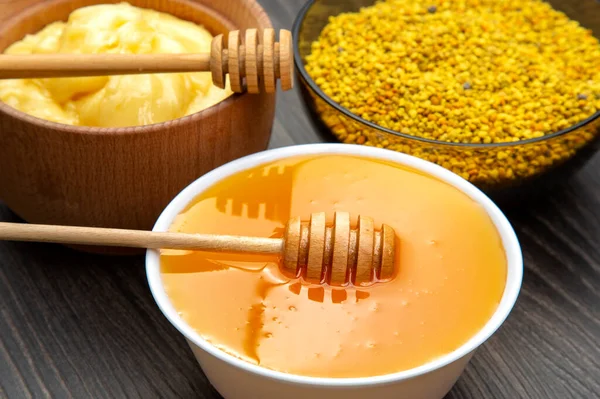 Farklı çeşitlerde taze çiçek balı, polen ve ahşap arka planda kaşıkları olan bal peteği. Organik Vitamin Sağlıklı Gıda