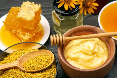 Farklı çeşitlerde taze çiçek balı, polen ve ahşap arka planda kaşıkları olan bal peteği. Organik Vitamin Sağlıklı Gıda
