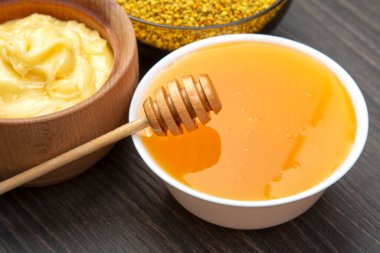 Farklı çeşitlerde taze çiçek balı, polen ve ahşap arka planda kaşıkları olan bal peteği. Organik Vitamin Sağlıklı Gıda