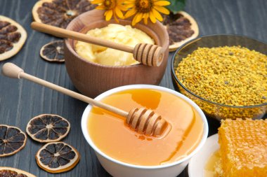 Farklı çeşitlerde taze çiçek balı, polen ve ahşap arka planda kaşıkları olan bal peteği. Organik Vitamin Sağlıklı Gıda