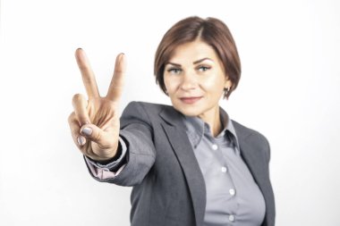 Takım elbiseli kadın zafer işaretini eliyle gösterdi.