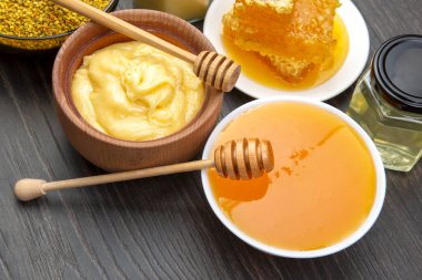 Farklı çeşitlerde taze çiçek balı, polen ve ahşap arka planda kaşıkları olan bal peteği. Organik Vitamin Sağlıklı Gıda