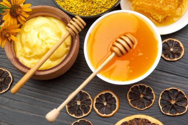 Farklı çeşitlerde taze çiçek balı, polen ve ahşap arka planda kaşıkları olan bal peteği. Organik Vitamin Sağlıklı Gıda