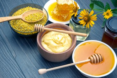 Farklı çeşitlerde taze çiçek balı, polen ve ahşap arka planda kaşıkları olan bal peteği. Organik Vitamin Sağlıklı Gıda